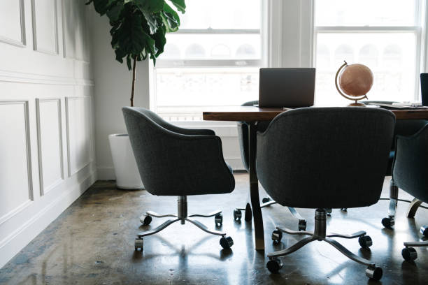 Simple workspace featuring wooden desk and chair with a lamp and plant. Elegant and modern home office setup.