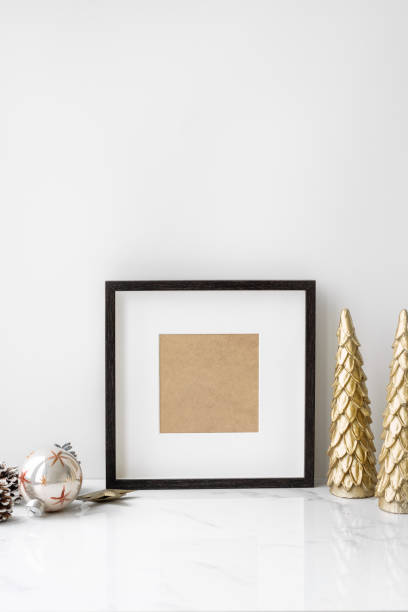 istock Picture frame on a table with golden Christmas tree 2157031712