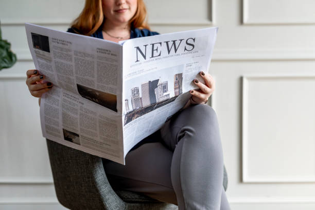 istock Woman reading the newspaper at home 2157032623