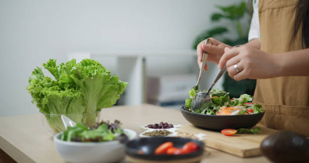 istock Young woman's hands making vegetable salad in home kitchen. 2157033090
