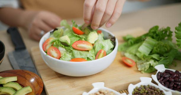 istock Young woman's hands making vegetable salad in home kitchen. 2157033162
