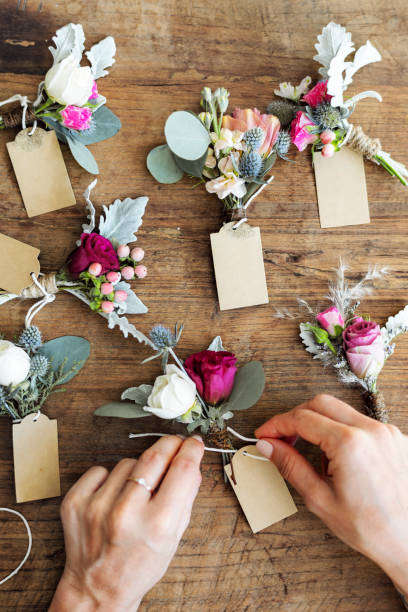 istock Hands creating boutonnieres with paper tags 2157035026