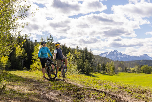 istock Senior couple with mountain bikes in mountain meadow 2157035132