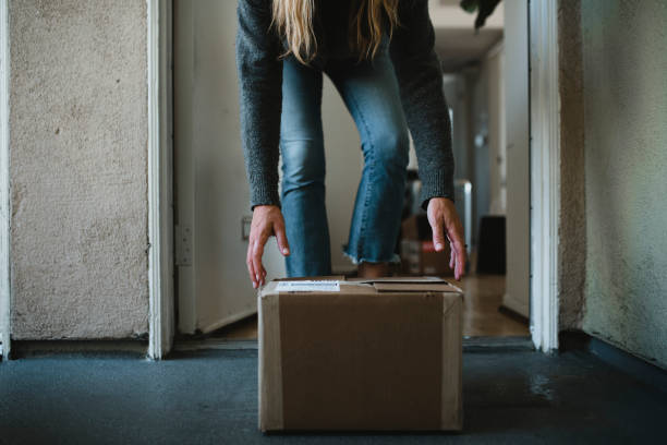 istock Woman getting her package from the front door during the coronavirus pandemic 2157039802