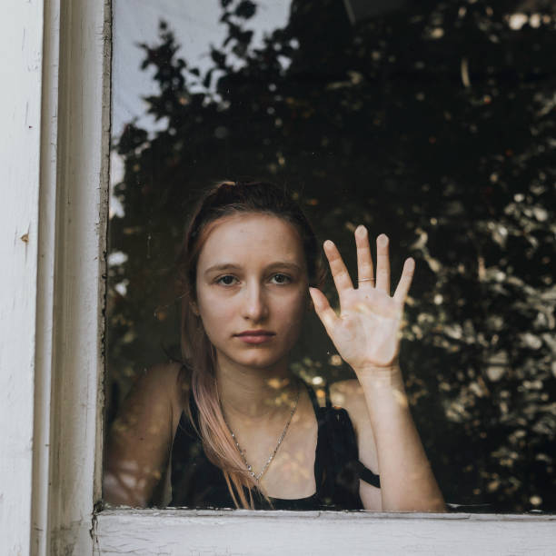 istock Sad girl staring out the window during a lockdown. 2157039885