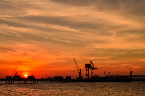 Quay crane standing on jetty harbor. Container handling equipment, heavy machinery for container logistics industry.