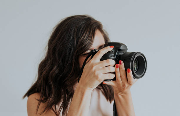 istock Female photographer holding digital camera 2157040556