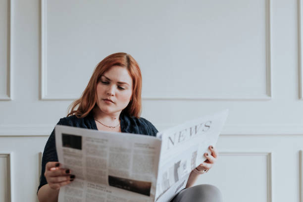 istock Woman reading the newspaper at home 2157040712