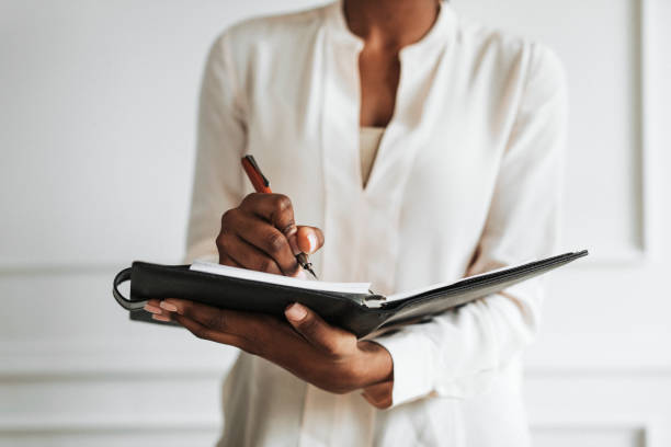 istock Businesswoman writing in a daily planner 2157040749