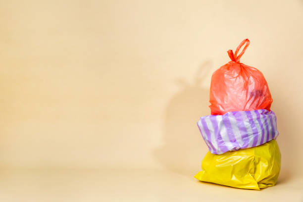 Colorful garbage bags isolated on yellow background
