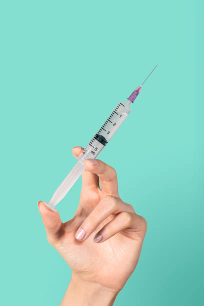 istock Feminine hand holding a syringe 2157043014