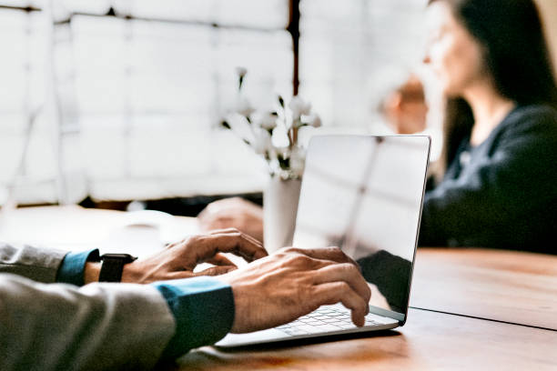 istock Man using a laptop on a wooden table 2157043282