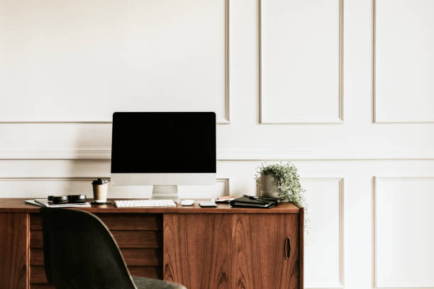 istock Computer by a daily planner on a wooden table 2157043594