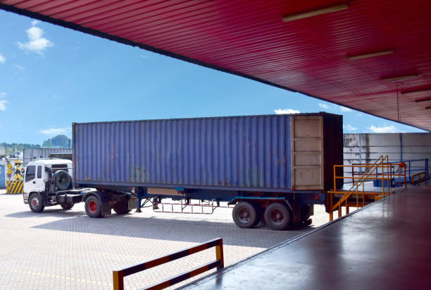 Truck align forty feet container to docking leveler to stuff cargo at distribution warehouse. Distribution, Logistics Import Export, Warehouse operation, Trading, Shipment, Delivery concept.