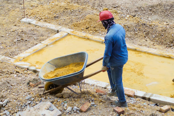 Bogota - Colombia, 22 may 2024. A male construction site worker standing with a wheelbarrow carrying sand from one place to another.
