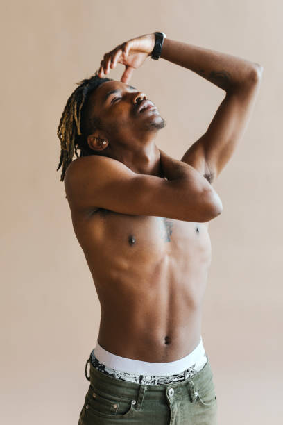 istock Black man stretching by a beige background 2157044361