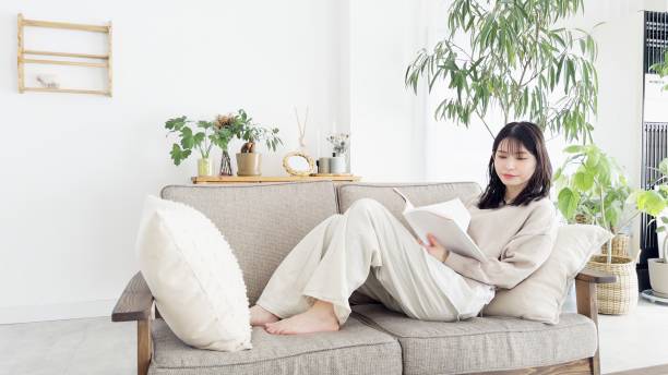 istock Woman reading a book on the sofa 2157048689