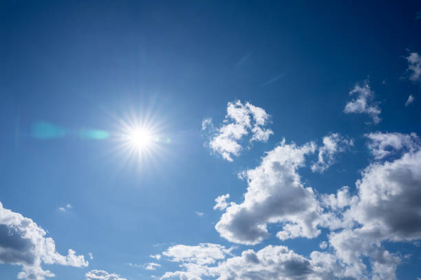 Bright summer sun in the blue sky with white clouds