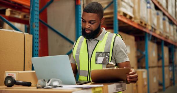 istock Man, laptop and checklist for inventory in warehouse, technology and research for logistics solutions. African worker, computer and stock taking for ecommerce and online order in distribution center 2157050076
