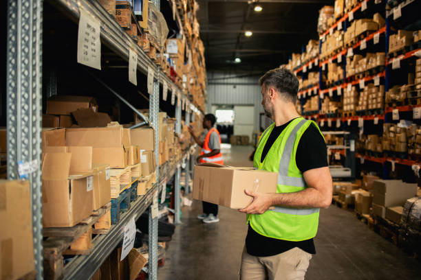 istock Warehouse staff members arranging boxes on the shelves 2157050673