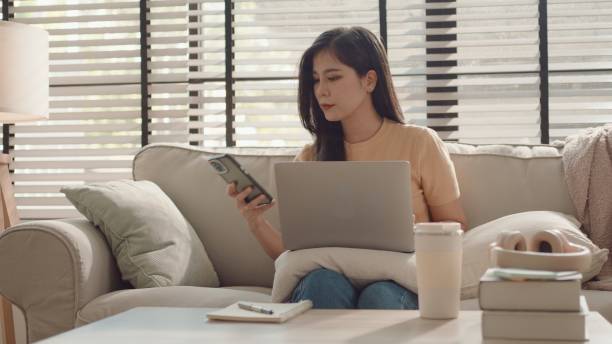istock Asian woman using smartphone at home, working at home 2157051060