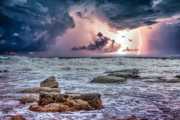 istock sea ocean white waves ,rocks at the shore and a storm sky with lightning 2157053403