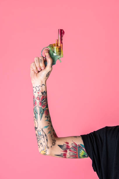 istock Feminine tattooed hand raising up a rainbow gun 2157053681