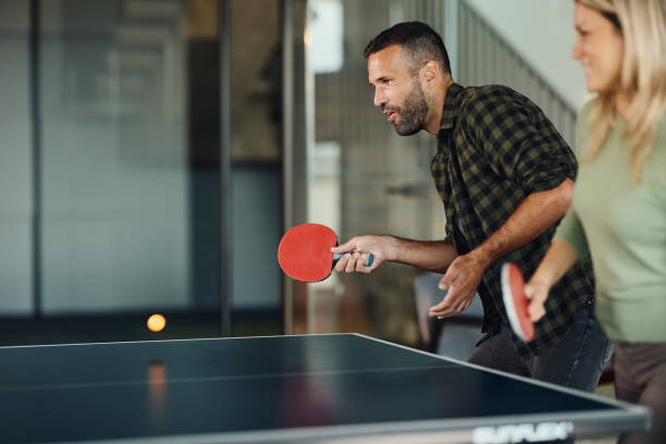 istock Carefree couple having fun while playing table tennis. 2157054780