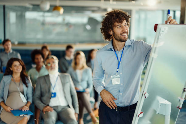 Happy male CEO drawing plans during presentation in board room.