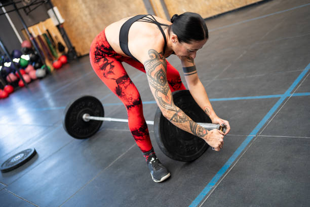 istock Woman preparing a bar with weights to weightlifting 2157055282