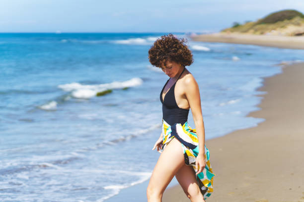 istock Female tourist with beach wrap on sunny seacoast 2157055414