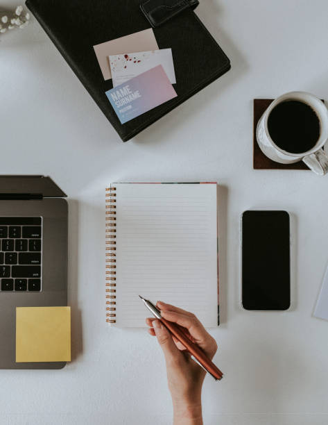istock Woman writing on a notepad by a laptop 2157055925