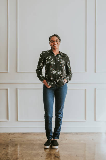 istock Happy empowering black woman standing by a white wall 2157056024