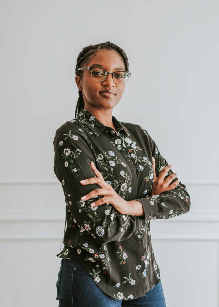 istock Happy empowering black woman standing by a white wall 2157056034