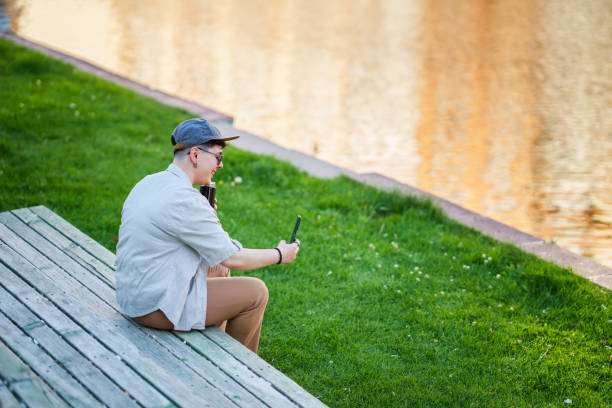 istock Young woman resting next to waterfront, using mobile phone. 2157056550