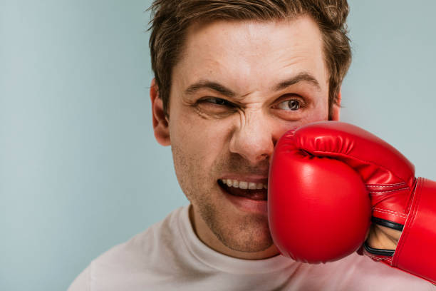 istock Man  getting hit with a red boxing glove 2157057303