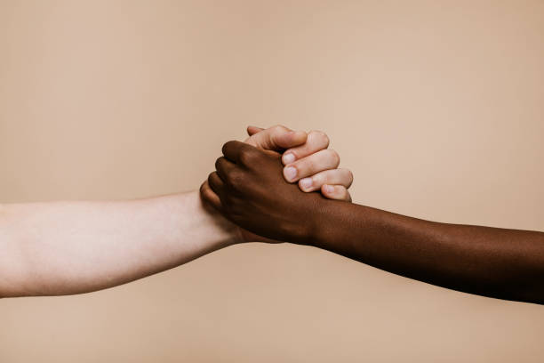 istock Black hand holding the white hand 2157057475