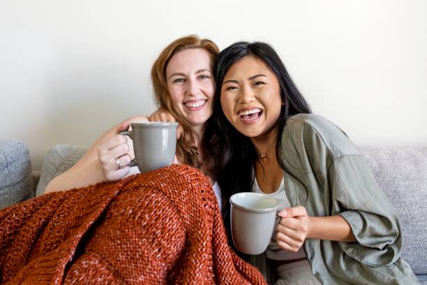 istock Female couple cuddling on sofa in morning 2157058919