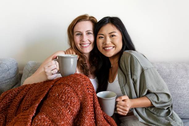 istock Female couple cuddling on sofa in morning 2157058920