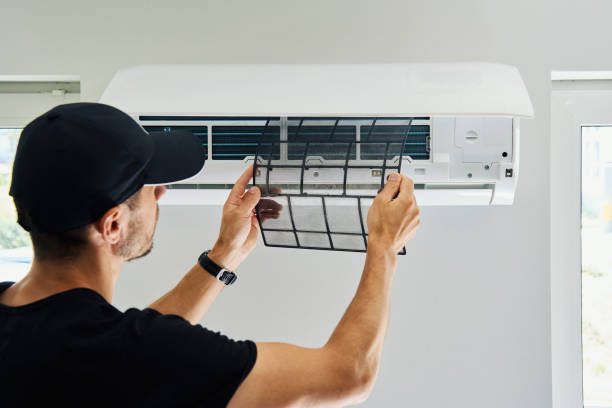 Air conditioner maintenance. Male technician repairing cooling system