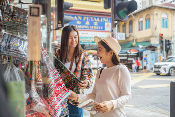 female travelers looking at typical clothes in typical handicraft of street market