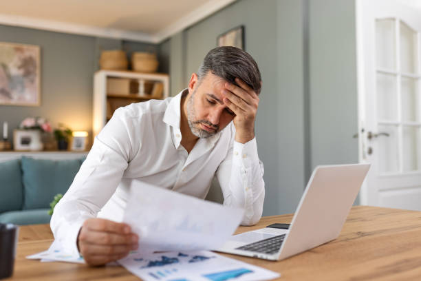 istock Handsome man freelancer noting information for planning project doing remote job via laptop computer. Man reading email on modern laptop device . 2157063028