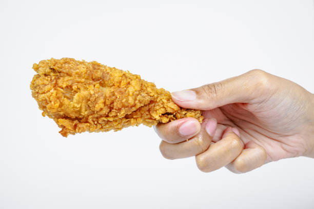 istock Female hand holding fried chicken on white background. 2157063827