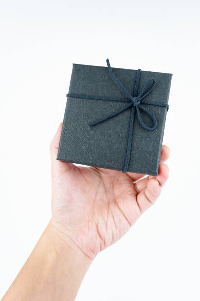 istock Hand holding black gift box on white background. 2157064022