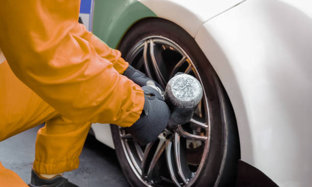 istock Auto mechanic changing car wheel in garage. 2157064437