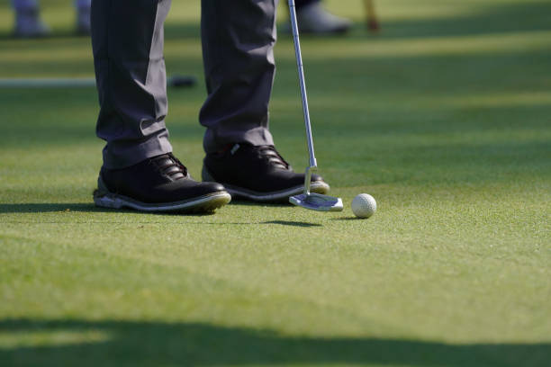 istock Glofer takes a stance to put a golf ball in the hole 2157065007
