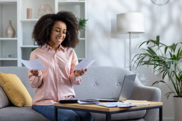istock Happy woman managing finances at home with laptop and documents 2157066157
