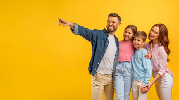 istock Father pointing and leading family on yellow 2157066168