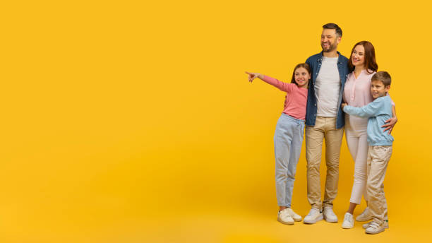 istock Family pointing to side on yellow backdrop 2157066183