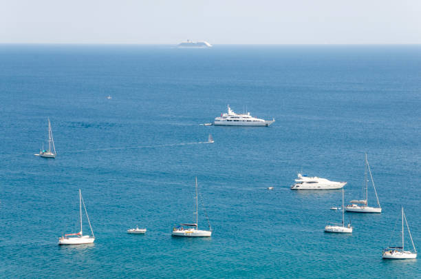 Numerous boats bobbing on water on a sunny day